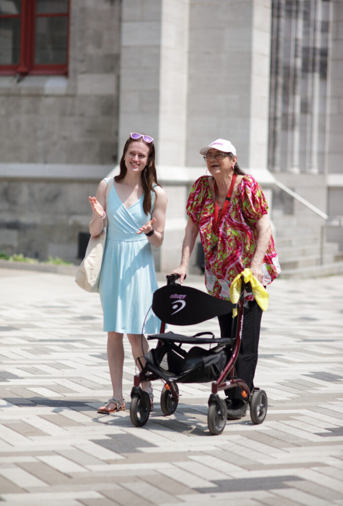 A young woman and a senior woman are walking together in downtown Montreal.